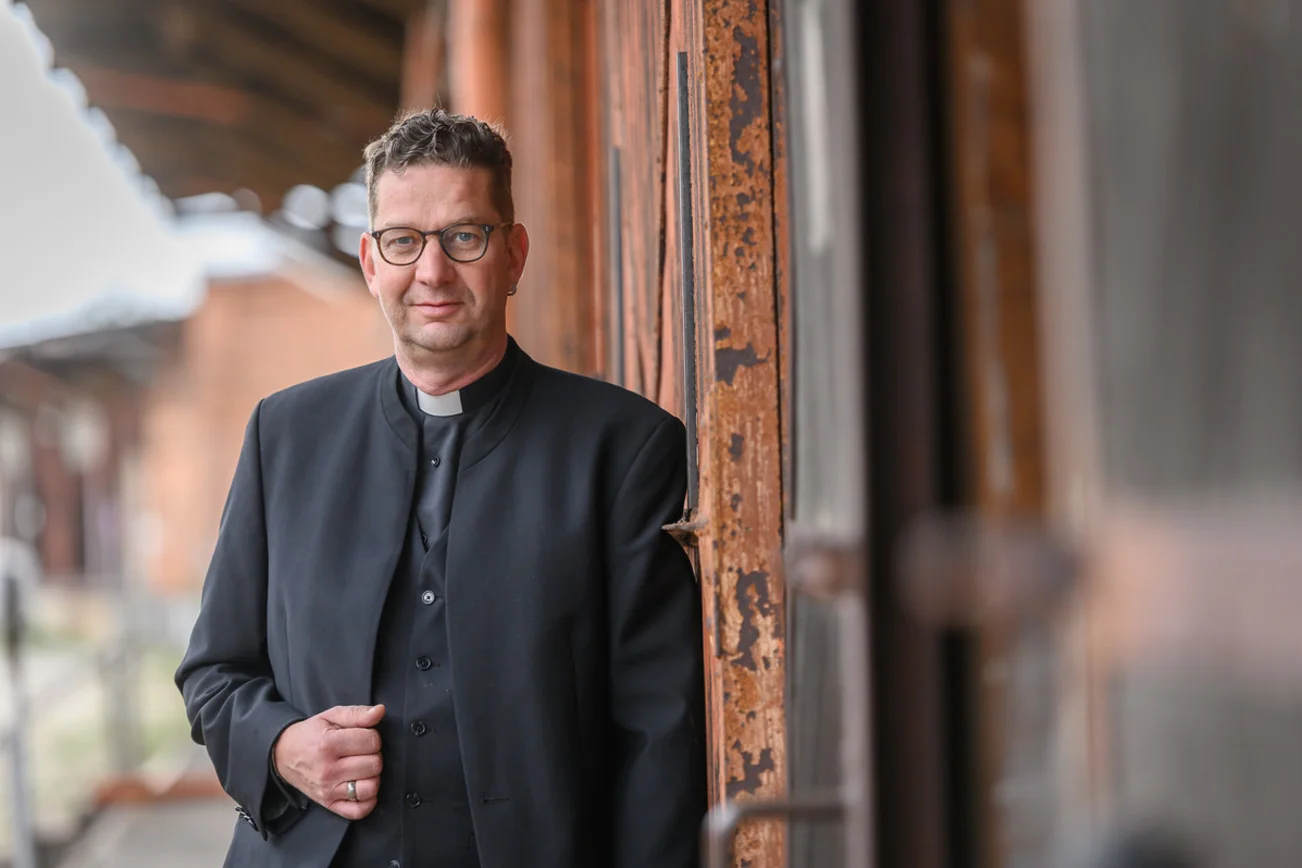 Ein Mann steht im Hafen und schaut in die Kamera. 