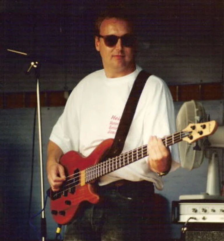 Mann spielt Bass-Gitarre.