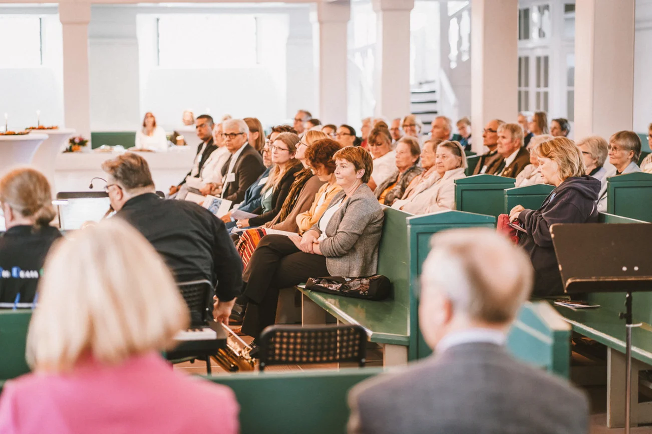 Menschen sitzen in einer Kirche.