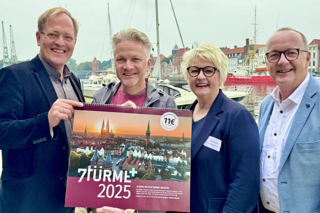 Vier Menschen halten einen Kalender in den Händen