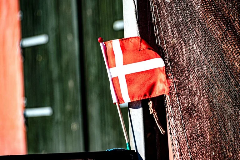 Eine dänische Flagge weht an einem Fischerboot. 