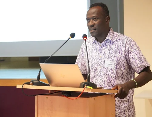 Ein Schwarzer Mann steht an einem Rednerpult. 