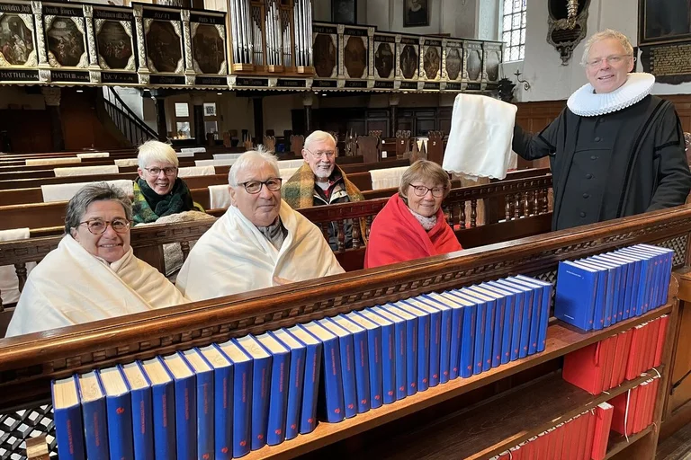 Menschen mit wärmenden Decken in einer Kirche