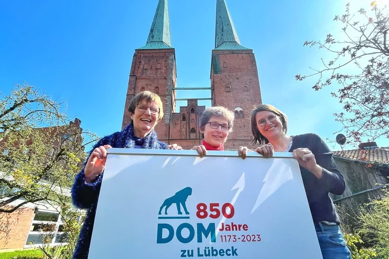 Drei Frauen vor dem Dom mit einem Roll-Up