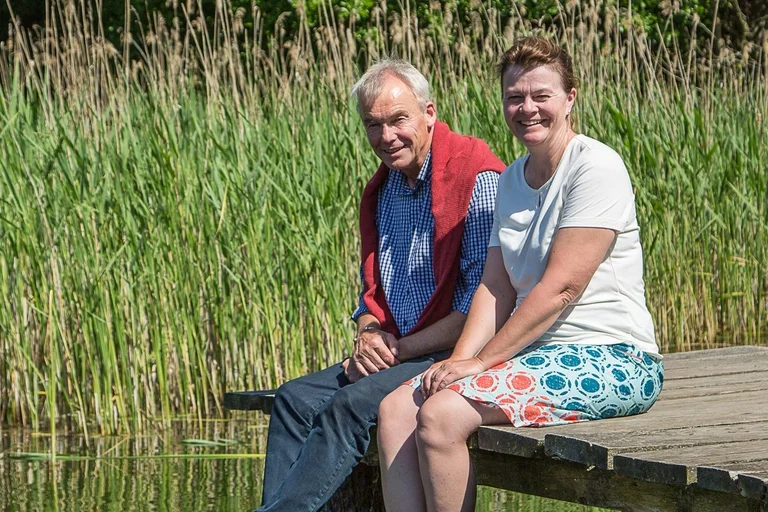 Ein Mann und eine Frau sitzen auf einem Steg