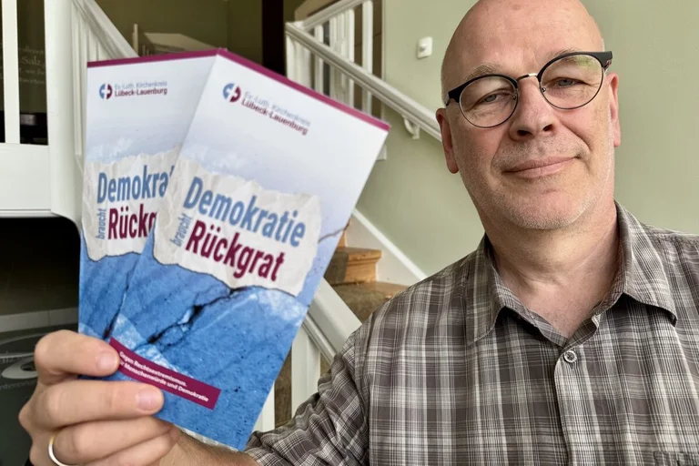 Ein Mann hält Flyer in der Hand 