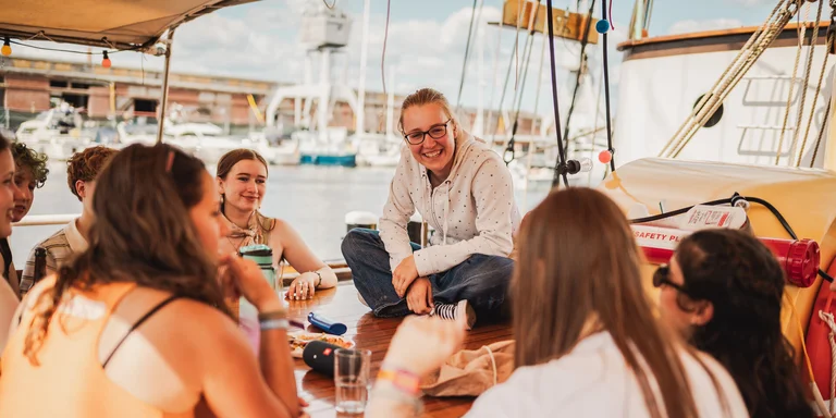Gruppe junger Menschen am Bord vom Segelschiff