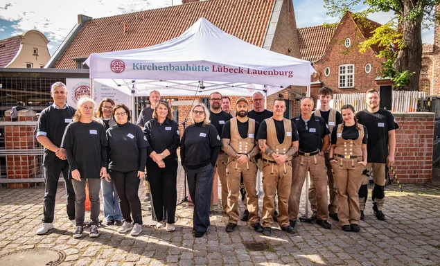 Gruppenfoto mit von Bauabteilung und Kirchenbauhütte zum Teil mit Handwerkerkluften.