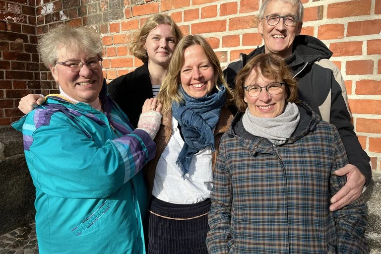 Eine Gruppe von Menschen schaut in die Kamera. 