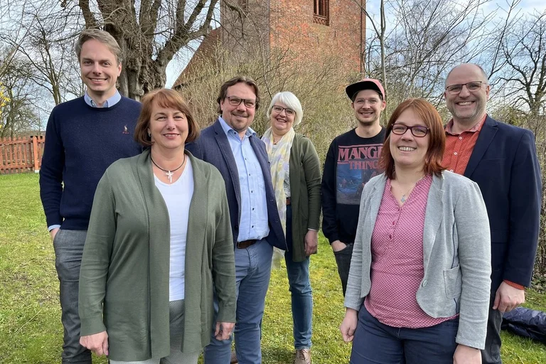 Eine Gruppe Menschen lächelt in die Kamera