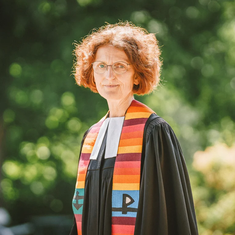 Frau im Talar steht im Freien