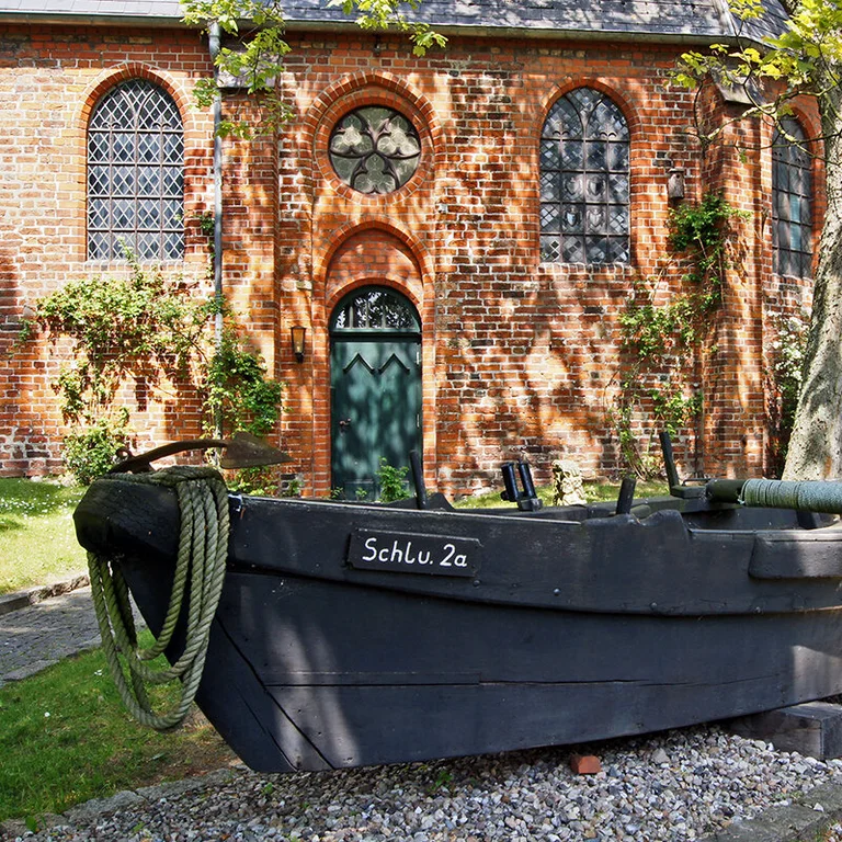letzter 1965 hier für Schlutuper Fischer gebauter Kahn, für Fang auf Trave bis 1986, dahinter Kirchenwand im Halbschatten          
