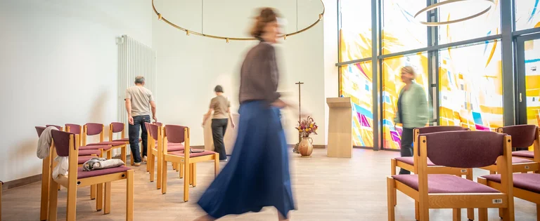 Menschen bewegen sich im Raum der Stille am UKSH