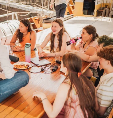 Gruppe junger Menschen am Bord vom Segelschiff